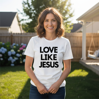 Woman wearing a white t-shirt with 'LOVE LIKE JESUS' text in a backyard setting.