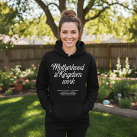 Woman wearing a black hoodie with text in a garden